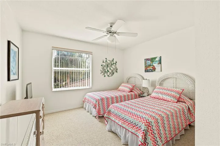 Carpeted bedroom featuring ceiling fan