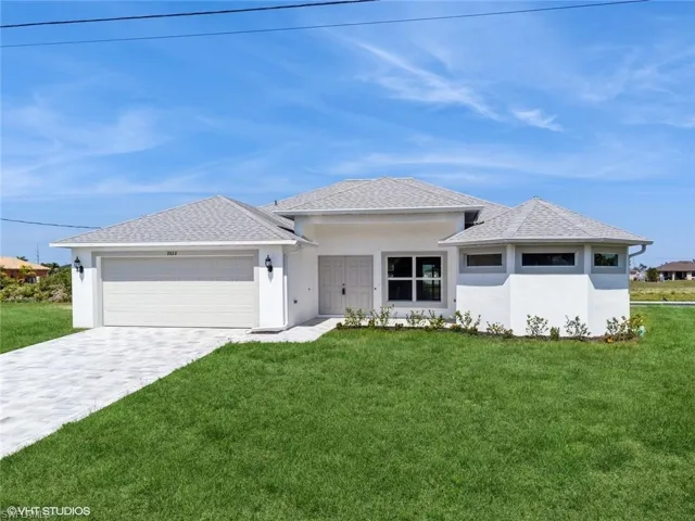 Prairie-style home with a garage and a front lawn