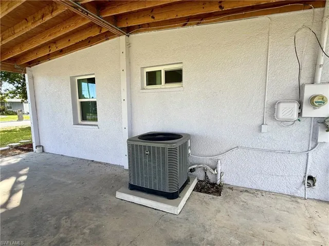 Exterior view of a central air condition unit and stucco siding
