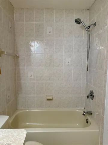 Bathroom with toilet and bathing tub / shower combination