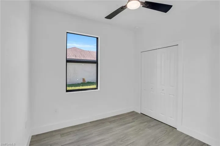 Unfurnished bedroom featuring ceiling fan, light hardwood / wood-style floors, and a closet