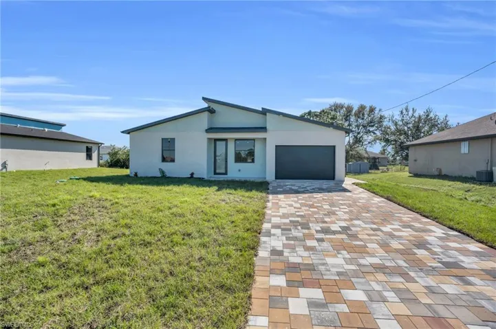 View of front of home featuring a garage and a front lawn