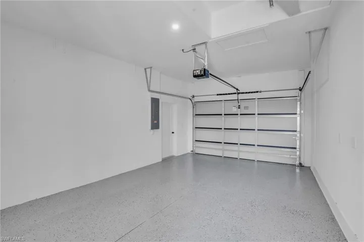 Garage featuring electric panel and a garage door opener