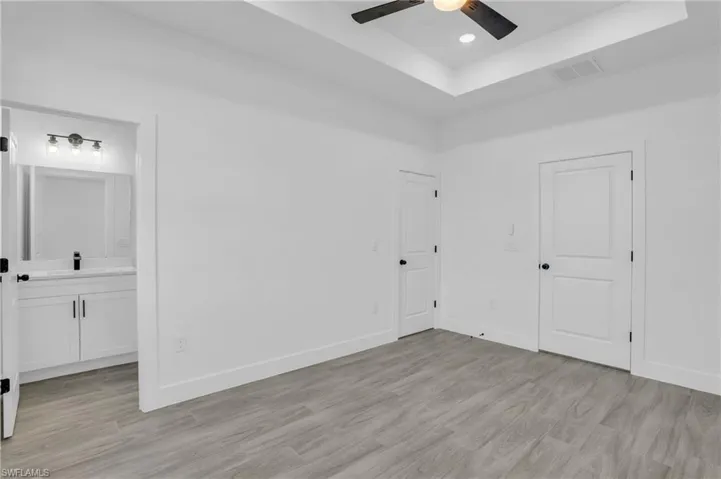Empty room featuring light hardwood / wood-style flooring, ceiling fan, and sink
