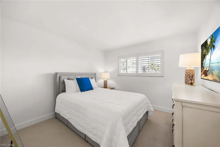 Bedroom with light carpet and baseboards