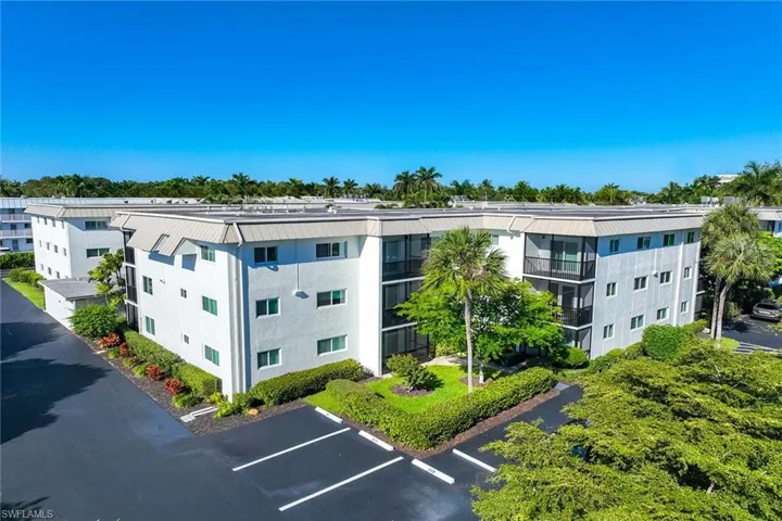 View of apartment building / complex with uncovered parking
