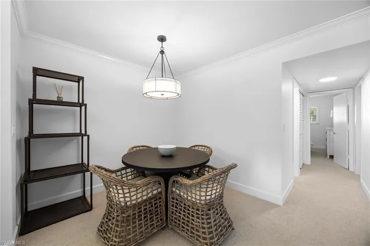 Dining room featuring light colored carpet and crown molding
