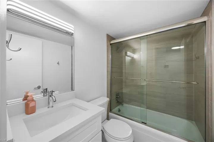 Full bathroom featuring vanity and shower / bath combination with glass door