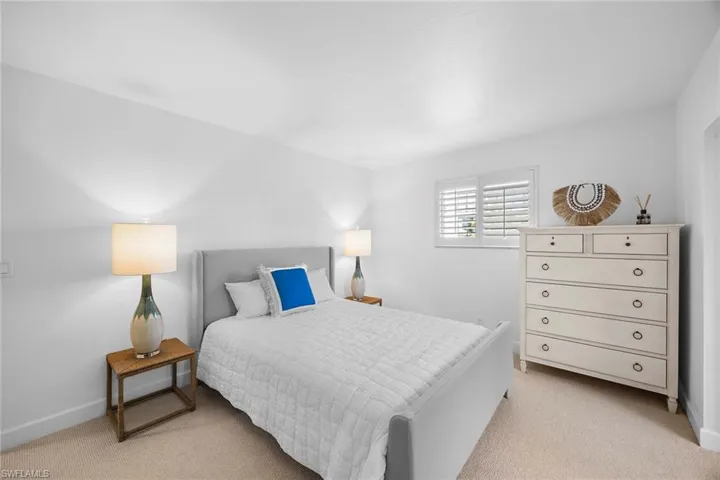 Bedroom with light colored carpet and baseboards