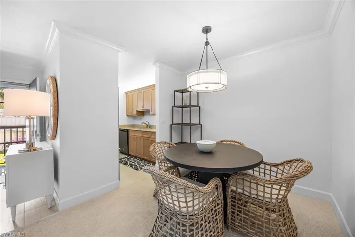 Dining area featuring ornamental molding and light carpet