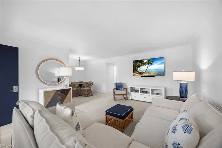 Living area featuring ornamental molding and carpet