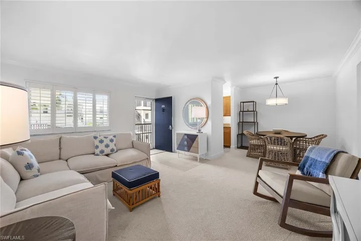 Living room featuring ornamental molding and light carpet