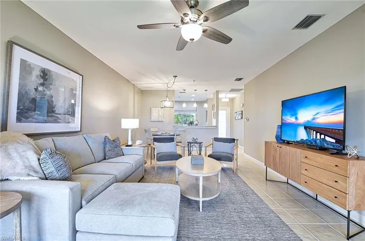 Living area featuring a ceiling fan and light tile patterned floors