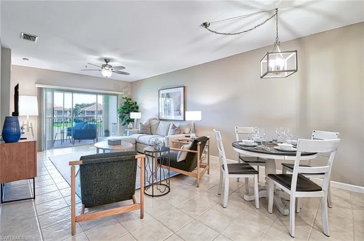 Living room with a ceiling fan and light tile patterned floors