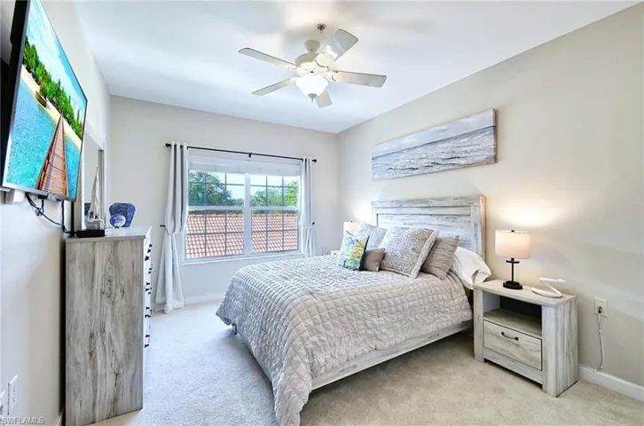 Bedroom with light colored carpet and ceiling fan