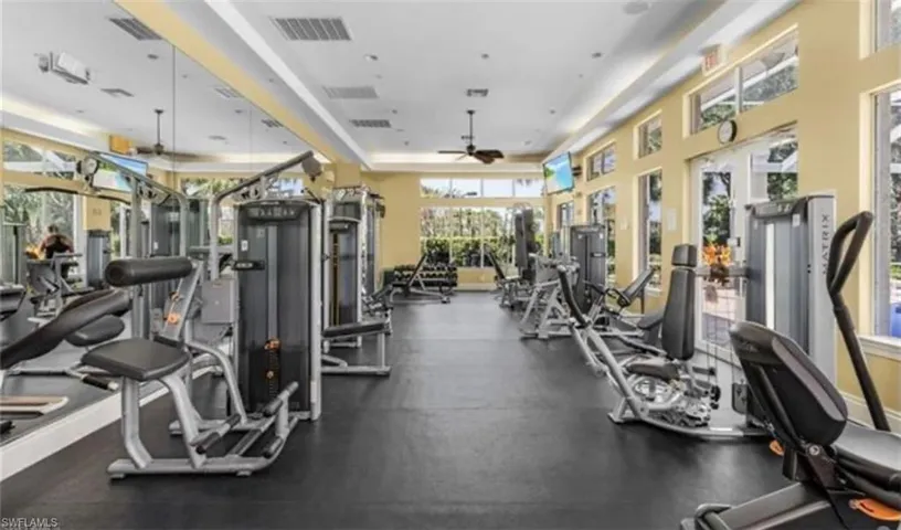 Gym with a ceiling fan and a raised ceiling