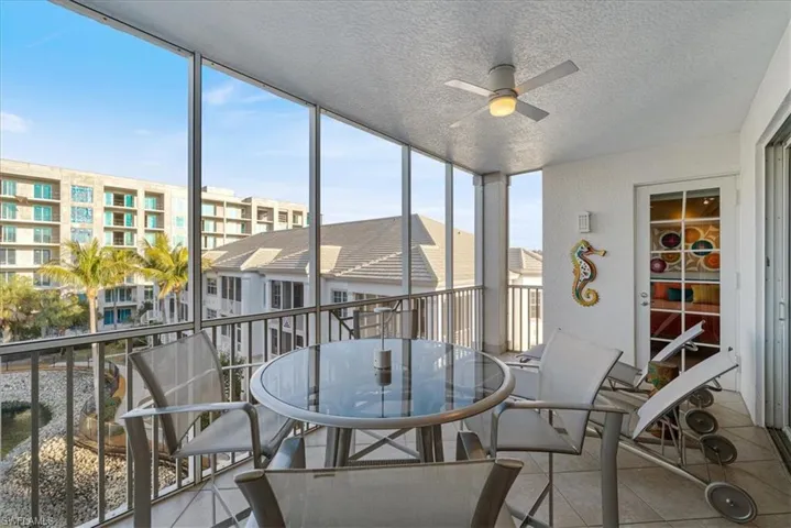 Sunroom / solarium with a balcony, a ceiling fan, and outdoor dining area