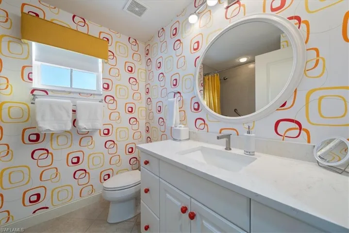 Bathroom featuring wallpapered walls, a shower with shower curtain, vanity, and light tile patterned flooring