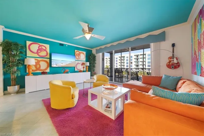 Living room with tile patterned flooring, crown molding, and a ceiling fan