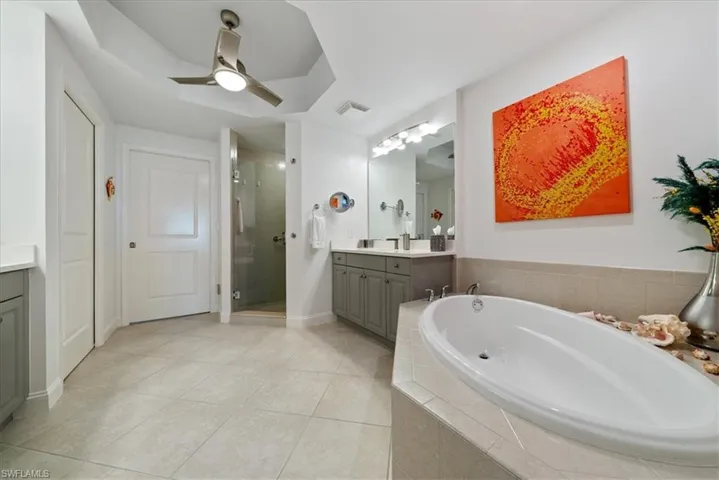 Full bath with vanity, a garden tub, light tile patterned floors, a shower stall, and ceiling fan