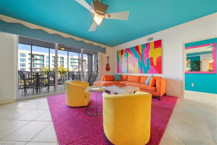 Tiled living room with crown molding and a ceiling fan