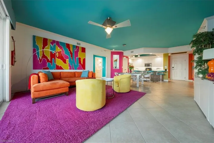 Living area featuring light tile patterned floors, a ceiling fan, and ornamental molding