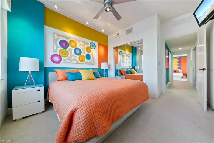 Carpeted bedroom featuring ceiling fan and a closet