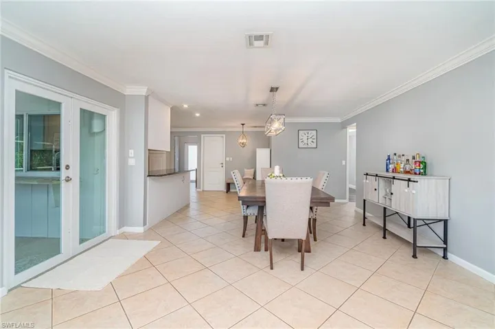 Tiled dining space featuring crown molding