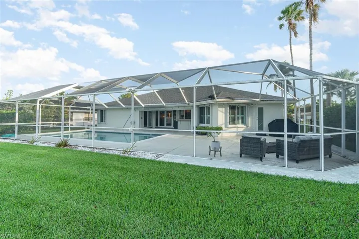 Rear view of property with an outdoor hangout area, glass enclosure, a yard, and a patio area