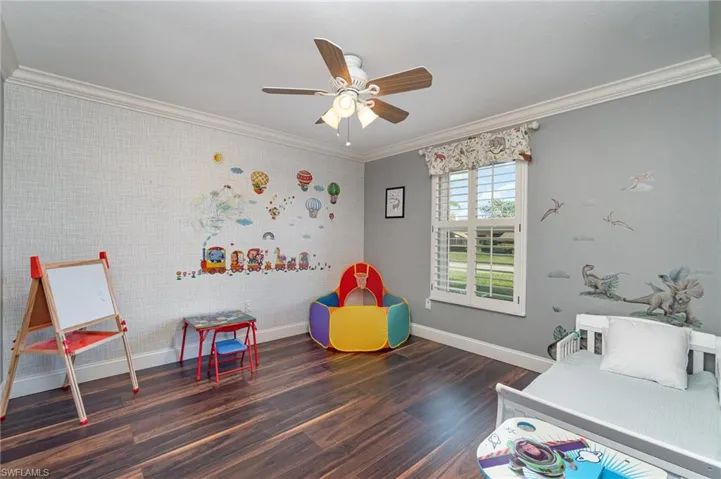 Bedroom featuring ceiling fan, dark hardwood / wood-style floors, and crown molding