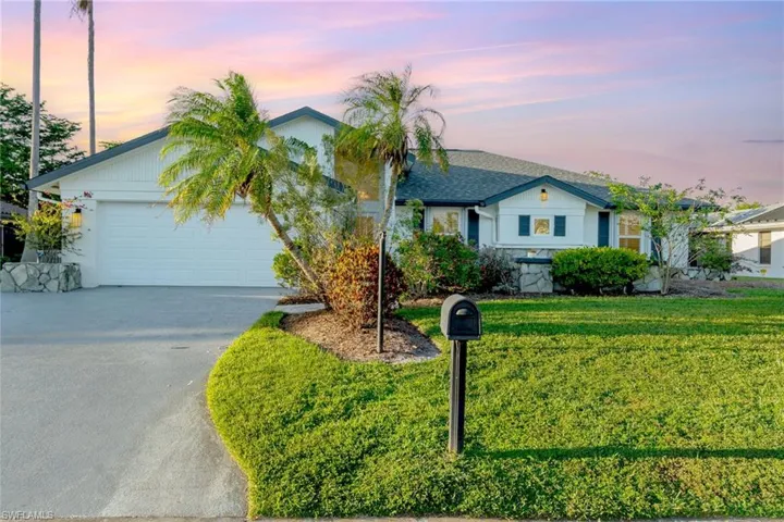 Single story home featuring a garage and a yard