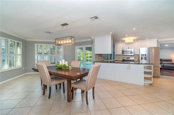 Tiled dining space featuring ornamental molding