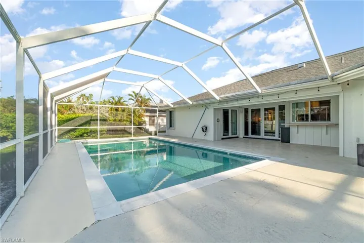 View of swimming pool with a patio area, french doors, and a lanai