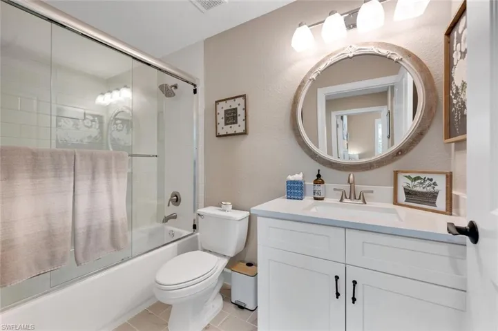 Guest bathroom with quartz countertops, combination shower & tub.