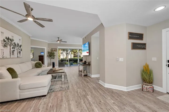 Great room featuring ceiling fan, light wood-style floors, and crown molding
