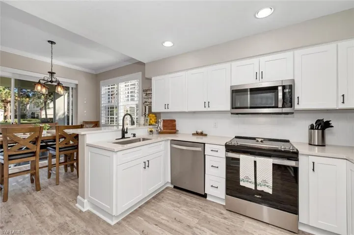 Kitchen with white cabinetry, sink, and stainless steel appliances