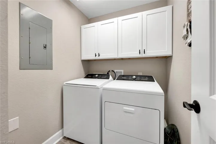 Laundry featuring new washer & dryer with extra storage above.