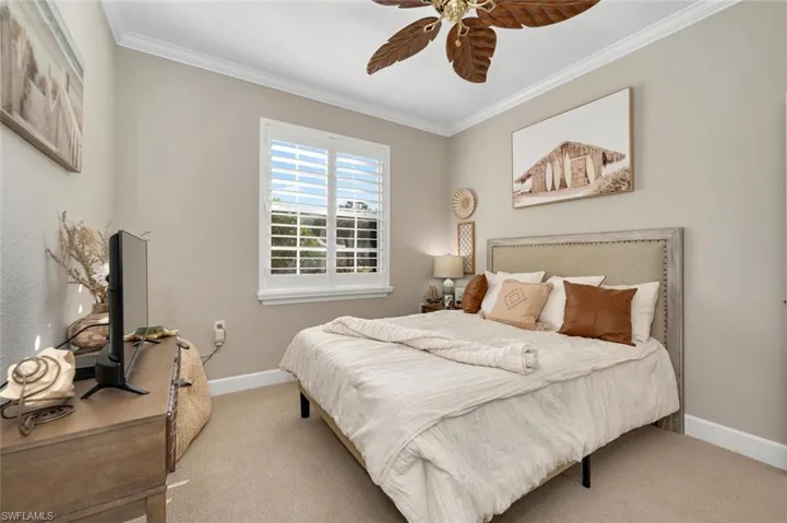 Bedroom featuring carpet flooring, ceiling fan, and ornamental molding