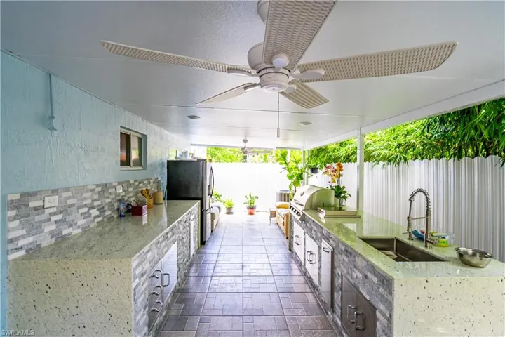 View of patio with ceiling fan, sink, a grill, and exterior kitchen