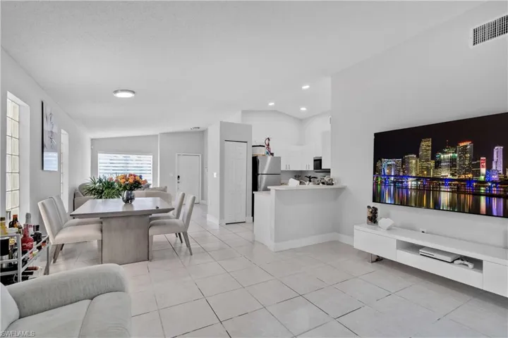Tiled living room featuring vaulted ceiling