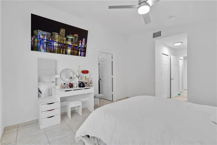 Tiled bedroom featuring ceiling fan