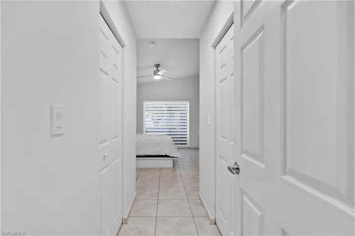 Hall with lofted ceiling and light tile patterned flooring