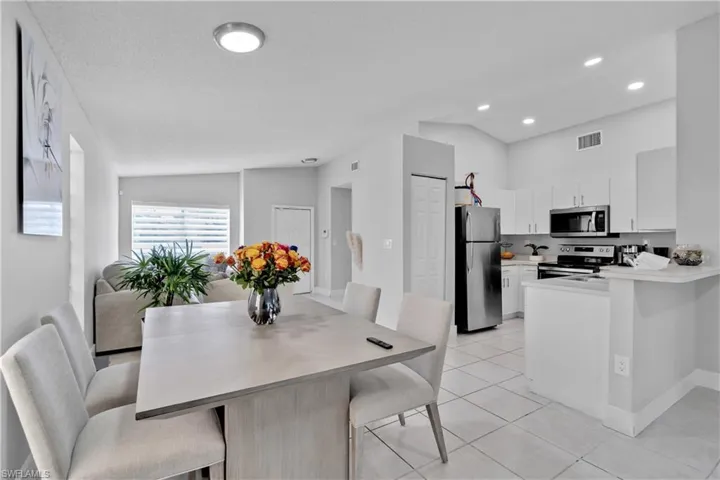 Dining area with light tile patterned flooring and lofted ceiling