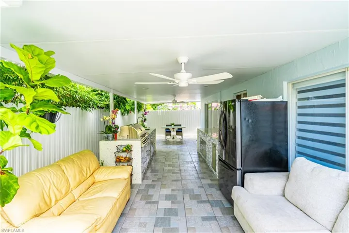 Living room with ceiling fan and tile patterned floors