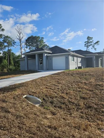 Ranch-style house featuring central air condition unit, a garage, concrete driveway, and stucco siding