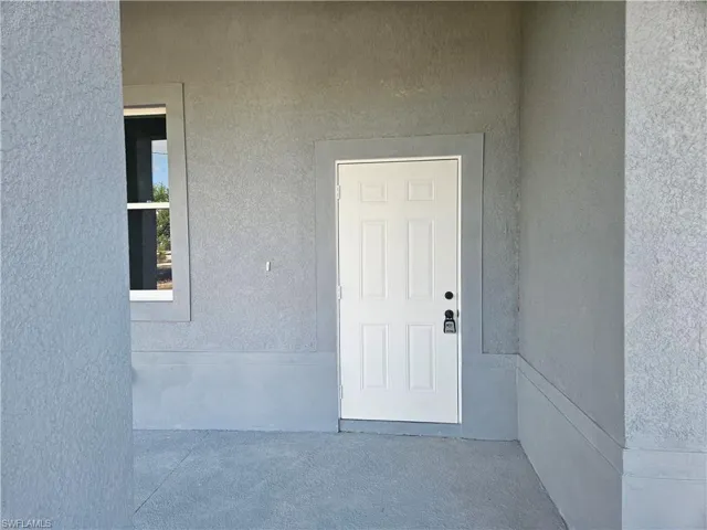 View of exterior entry featuring stucco siding