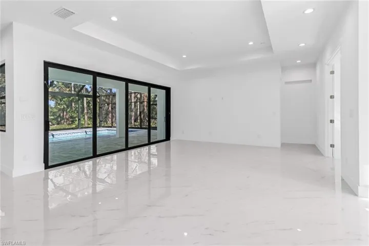 Spare room with light tile patterned floors and a tray ceiling