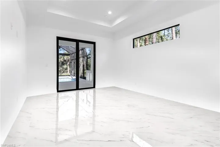 Spare room with light tile patterned flooring and a tray ceiling