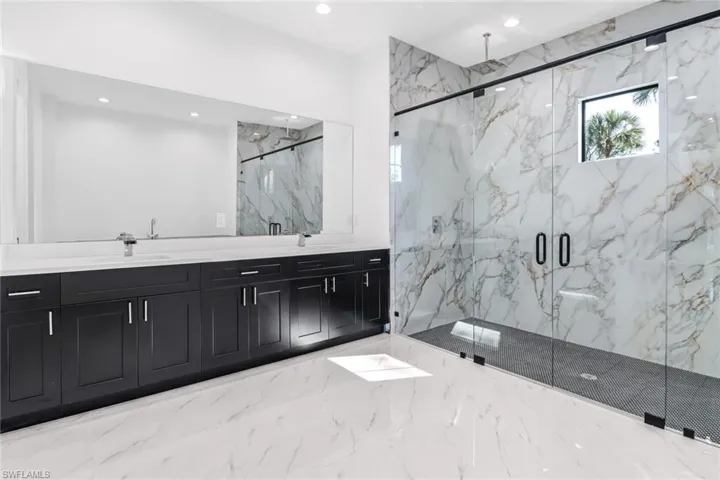 Bathroom featuring walk in shower and dual bowl vanity