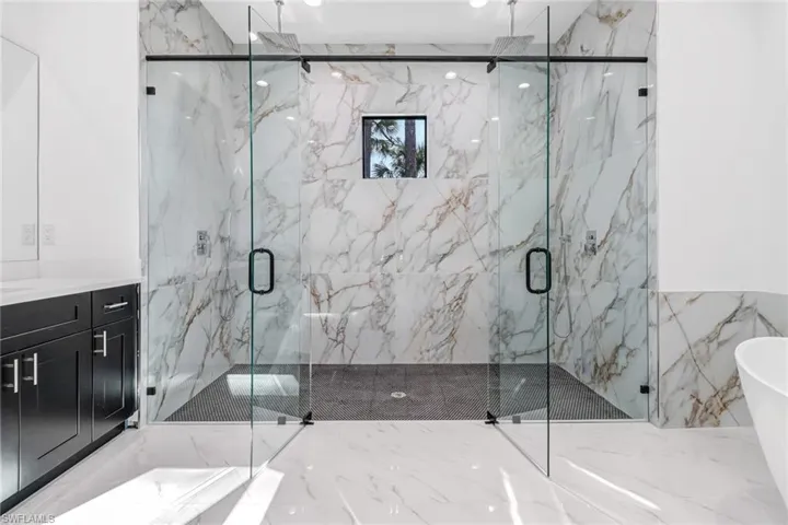 Bathroom featuring tile walls, independent shower and bath, tile patterned floors, and vanity